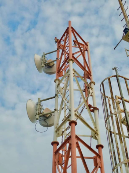Torre operacional com antenas de micro-ondas e escada de acesso